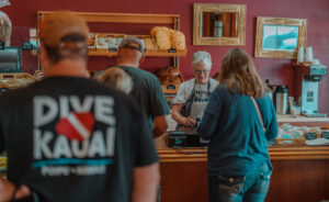 an employee at a bakery helping customers at the counter