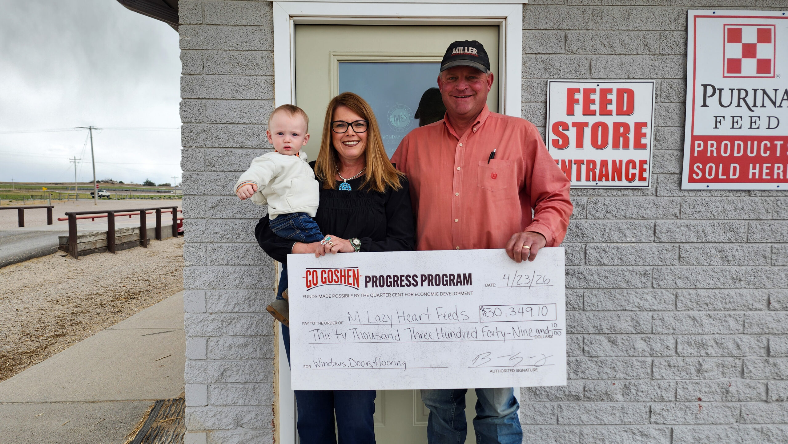 Christine and Paul Miller of M Lazy Heart Feed Store hold a Go Goshen Progress Program grant check outside their Torrington, Wyoming storefront.