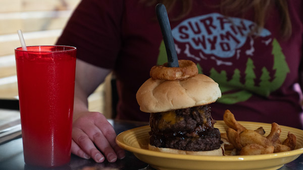 Broncho Grill House Father’s Day Dining Double cheeseburger topped with an onion ring and served with potato wedges and a fountain drink at Broncho Grill House in Torrington, Wyoming.