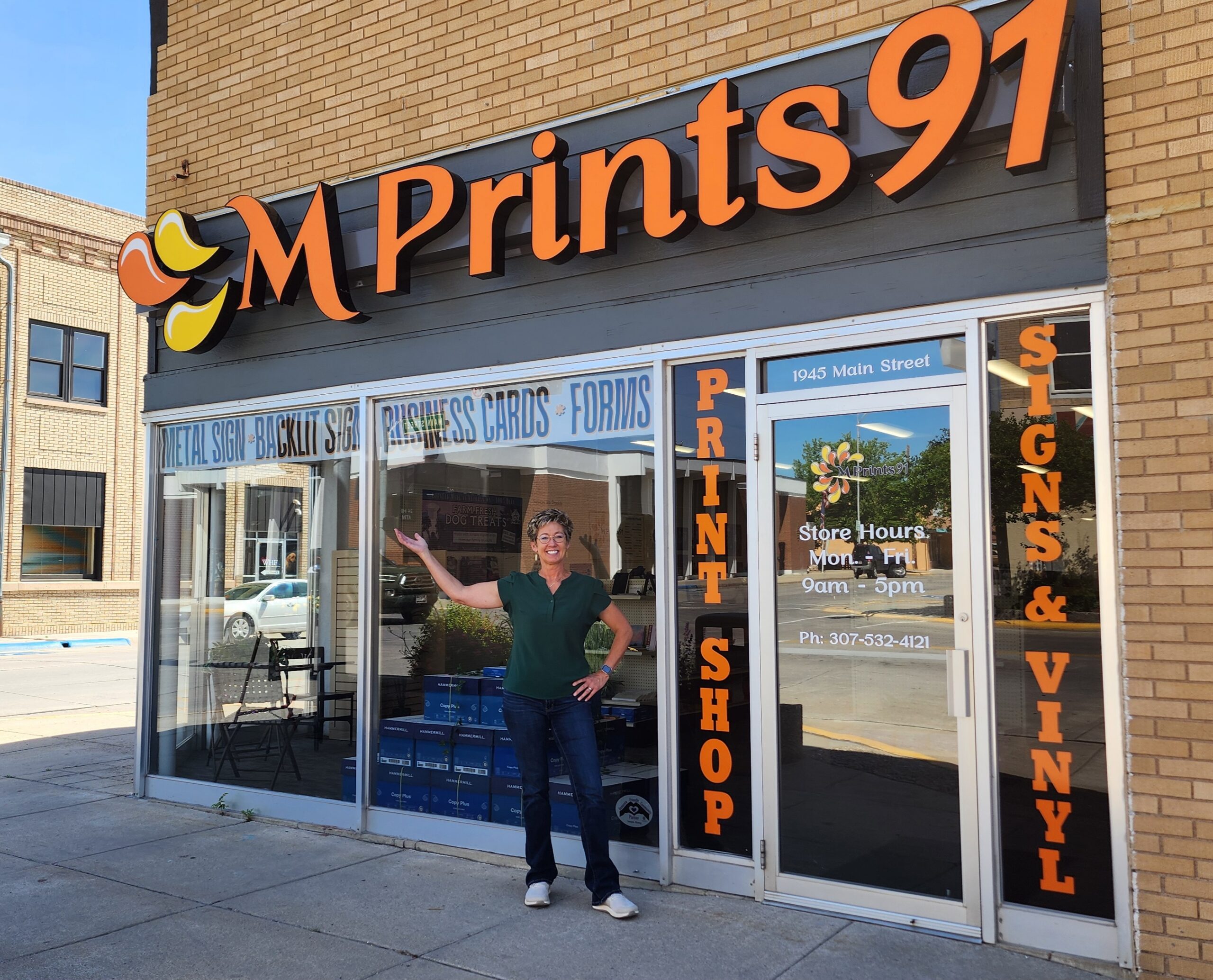 Linda, owner of MPrints91, stands outside the print shop in downtown Torrington, Wyoming. MPrints91 provides custom signs, banners, business cards, promotional products, and printing services.