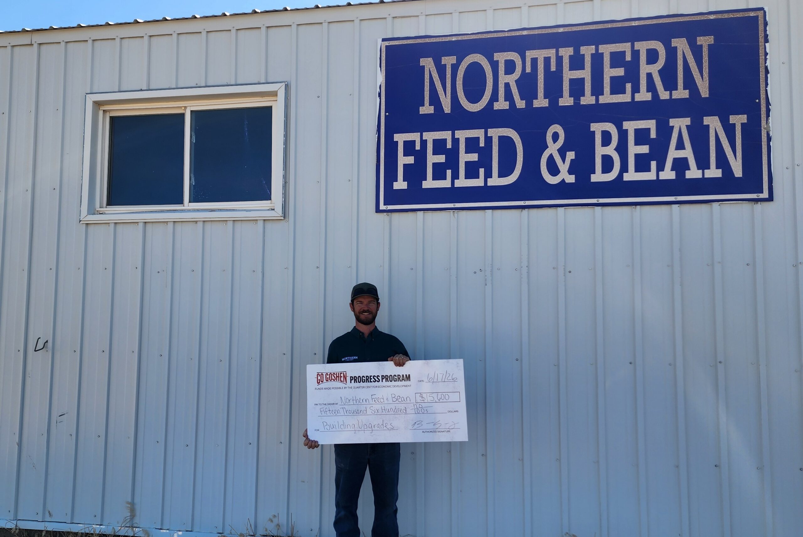 Brett Spencer of Northern Feed and Bean holds a $15,600 Go Goshen Progress Program award check outside the company’s Torrington facility.